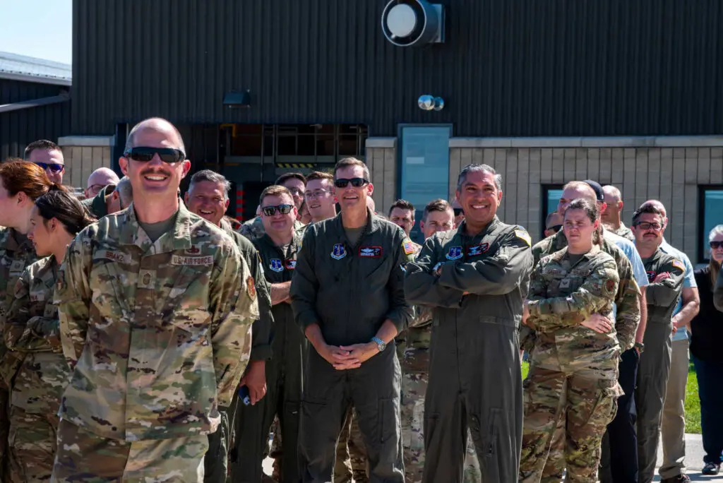 A group of military personnel standing at attention and smiling for the camera.