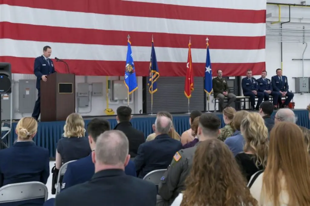 A presentation on a stage with a large American flag in the background