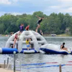 Campers jumping off a lake float at the Wisconsin National Guard’s Badger Youth Camp at Camp Lakotah.