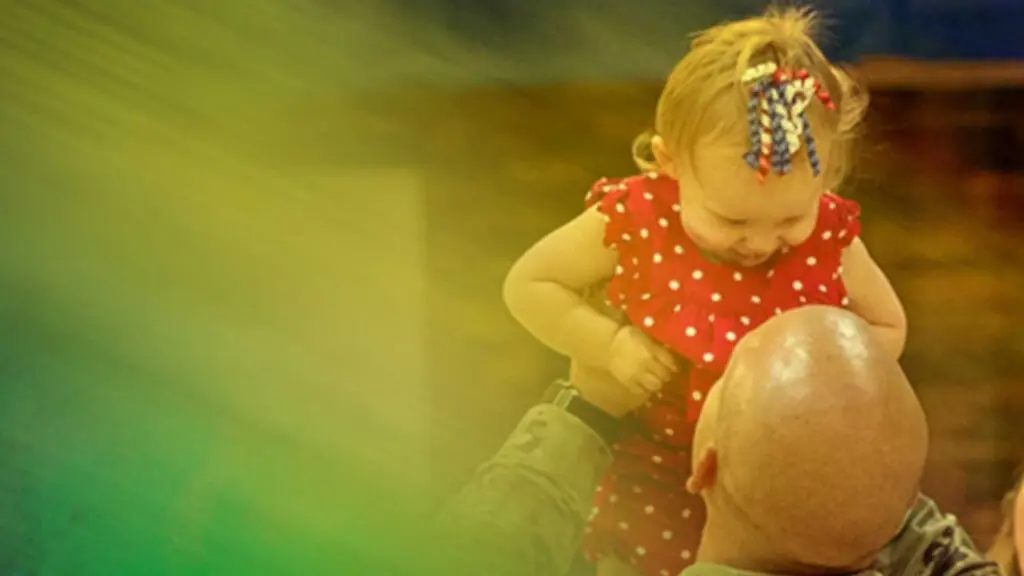 A soldier holding up his child during a home coming