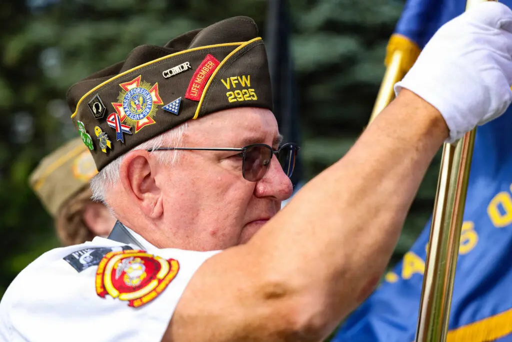 A veteran holding a flag during a ceremony