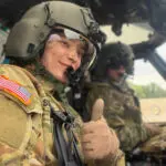 Jenna Sorenson giving the thumbs up in a helicopter