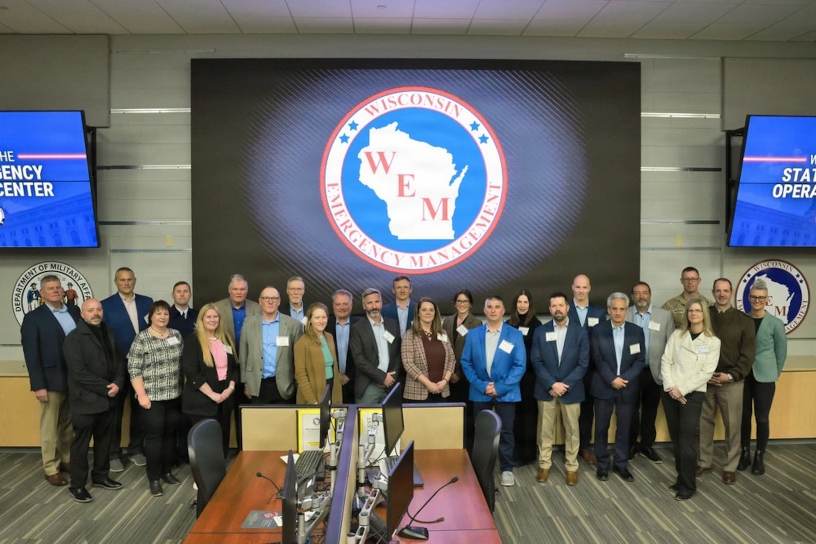 A team in front of a big Wisconsin Emergency Management logo