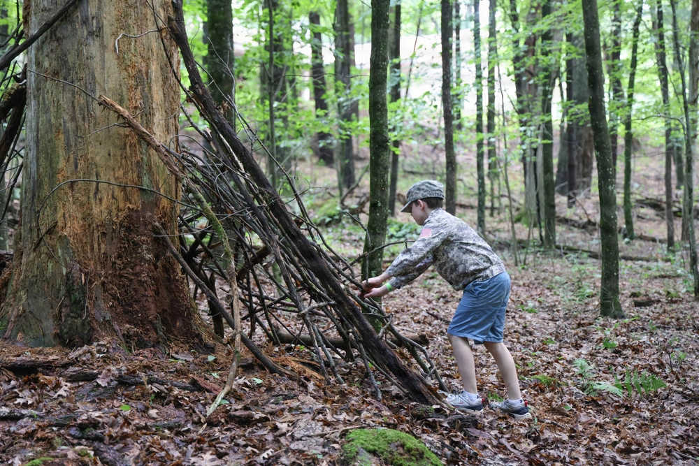 A camper builds an emergency shelter at the Wisconsin National Guard’s Badger Youth Camp at Camp Lakotah.