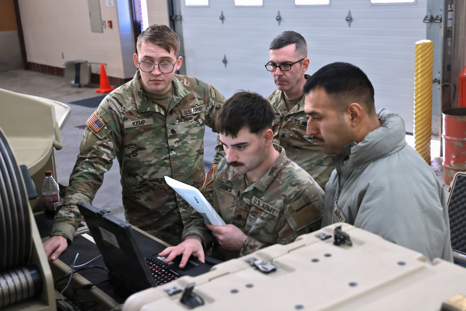 Soldiers working on equipment while following directions