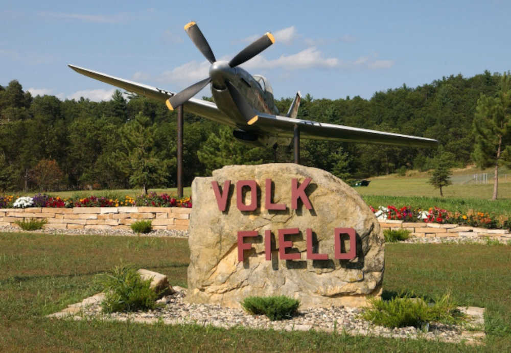 The sign Volk Field in front of a plane