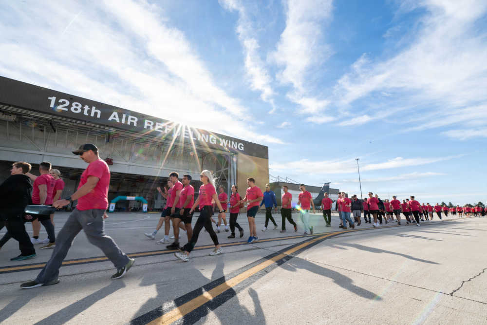 Service members walk around the flight line