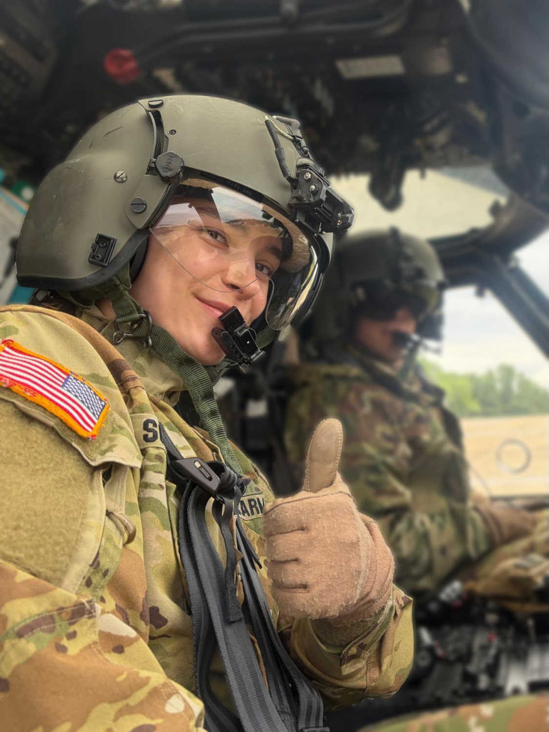 Jenna Sorenson giving the thumbs up in a helicopter