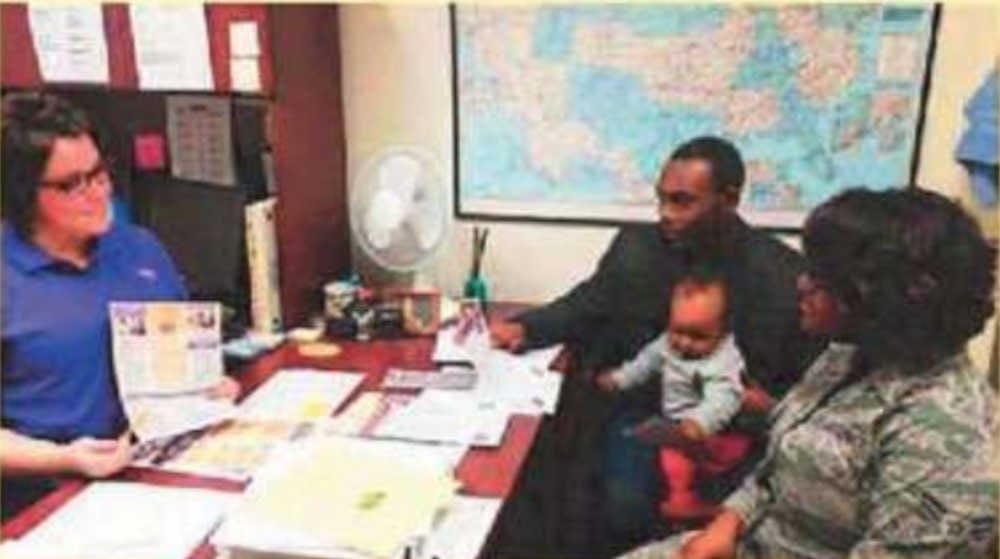 Someone at a desk talking to a family