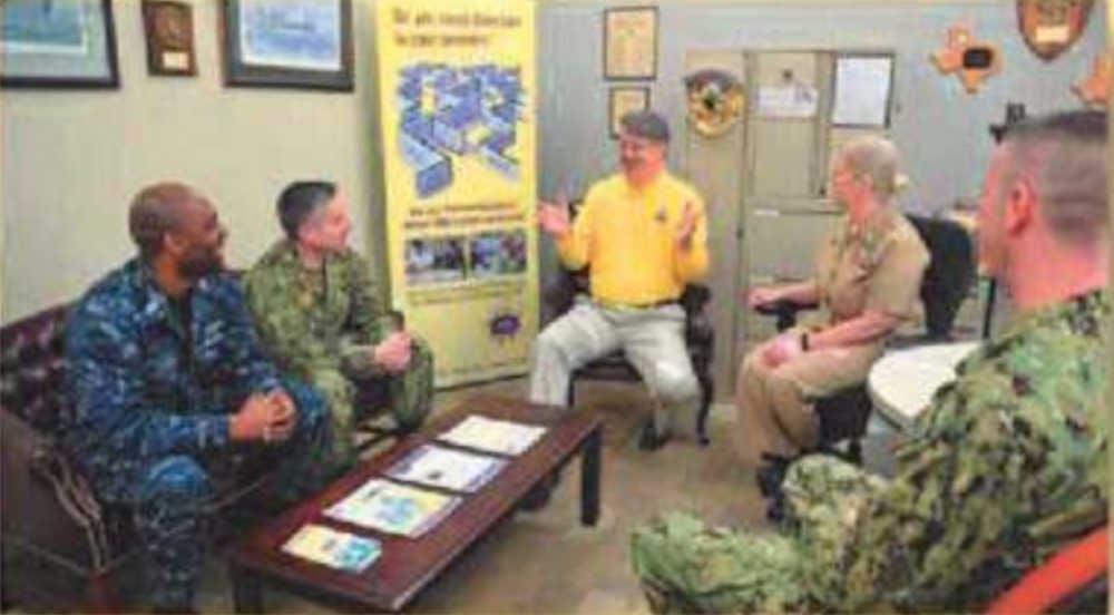 A smiling person giving a presentation to a group of people.